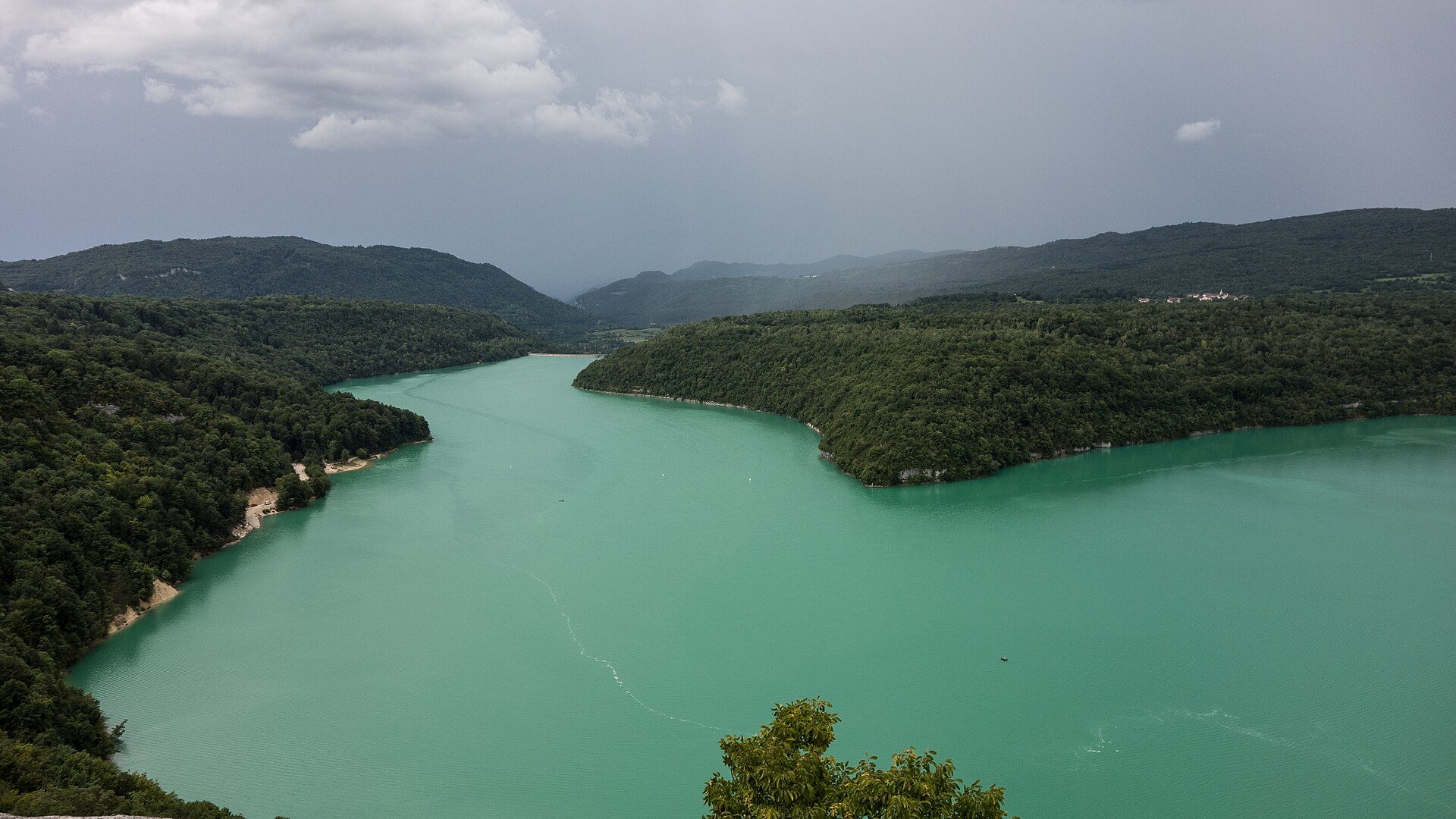 Le lac de Vouglans turquoise entre les forêts du Jura